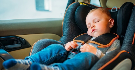 young child sleeping in a car seat