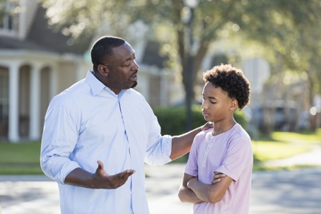Father talking to son on street